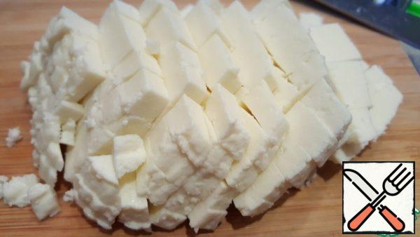 Cut Adyghe cheese into cubes. Put it in a salad bowl.
