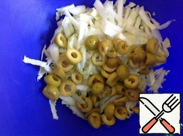 Chop the cabbage into strips, cut the olives into rings.
