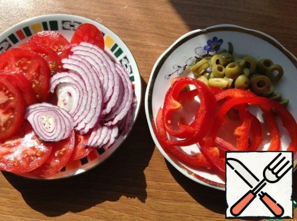 Onions, tomatoes, olives, and pepper cut into slices.