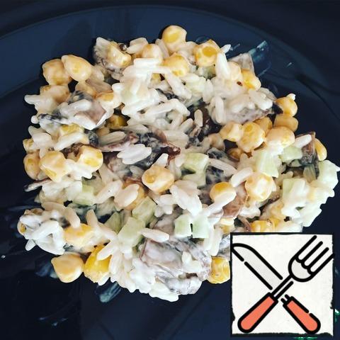 Rice is boiled, cool it down. Fresh mushrooms cut and fry in vegetable oil, cool. Peel the cucumber from the skin, cut into small cubes, drain the liquid from the corn. Mix all the ingredients, add salt and mayonnaise to taste! The salad is ready!