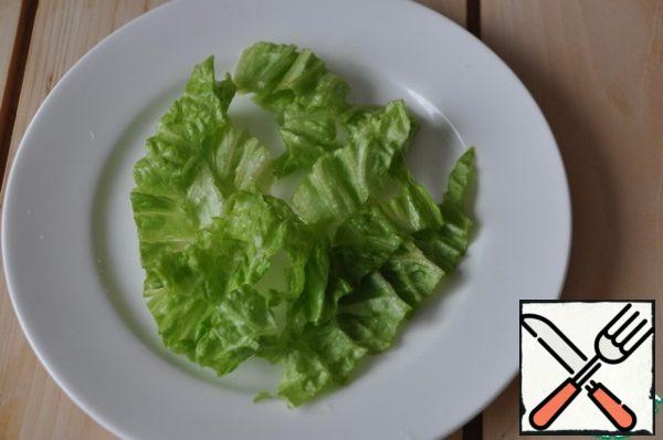 Salad can be decorated on a common dish, but I prefer serving on plates.
Lettuce leaves wash, dry with a paper towel, tear (or cut) and put on a plate.