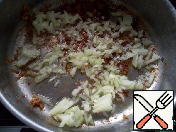 In the same saucepan, pour a little more oil and put the onion. Cook, stirring and scraping the pieces stuck to the bottom, on low heat for about 10-12 minutes, until the onion is soft.