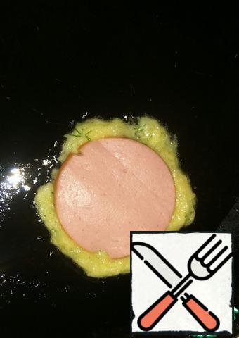 Put 0.5 St l of dough on the hot vegetable oil, quickly form a thin circle with a spoon and put the sausage on top, slightly pressing it into the dough.