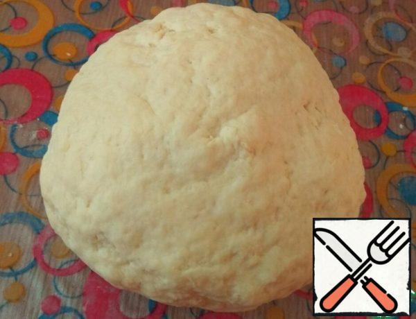 Add flour mixed with baking soda in parts.
Knead the dough so that it does not stick to your hands.
