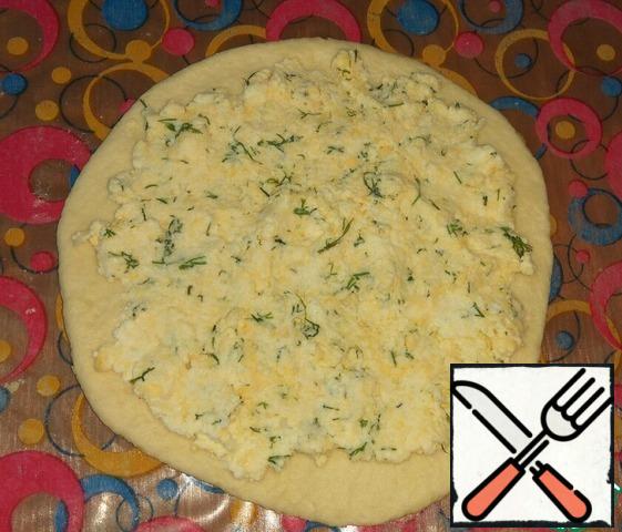 For the filling, mix the cottage cheese, grated cheese, crushed garlic and dill, add salt to taste. Stir. If cottage cheese dry, then can be add a bit sour cream or mayonnaise.
Spread the filling evenly on the rolled dough.