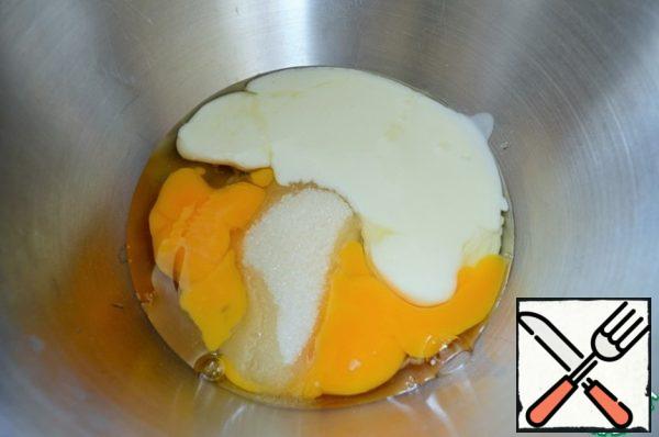 Turn on the oven to warm up.
In a bowl, mix eggs, 100 g of sugar, kefir, salt and soda.
