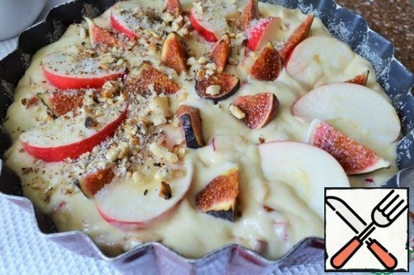 Put the dough in the form, level.
On it arrange the pieces of Fig and slices of Apple.
Mix the dried, chopped walnuts with 20 g of sugar,
sprinkle the pie.