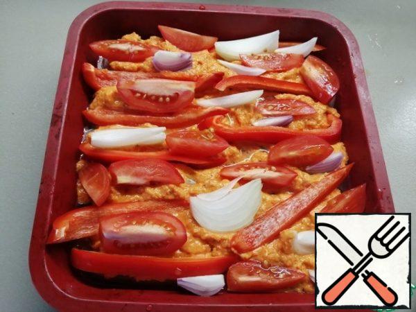Marinated chicken spread in a brazier, and on top of the sauce.
Take the remaining vegetables (tomato, bell pepper and onion) and cut them into slices. Spread on the sauce.