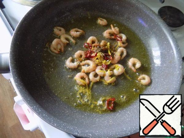 Add the zest, ginger and coriander, chili pepper. Stir and fry for about 2 minutes until the prawns have a Golden hue. Remove from heat and let them cool for a minute before putting the zucchini and juice.
