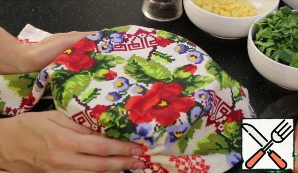 We will layer the dough in a warm way. The container in which the dough will be heated in the microwave. You can also pour boiling water. But with a microwave oven, it seems to me, it's easier.
Grease both the container and the dough with vegetable oil. Cover with a towel and leave for 30-40 minutes.
