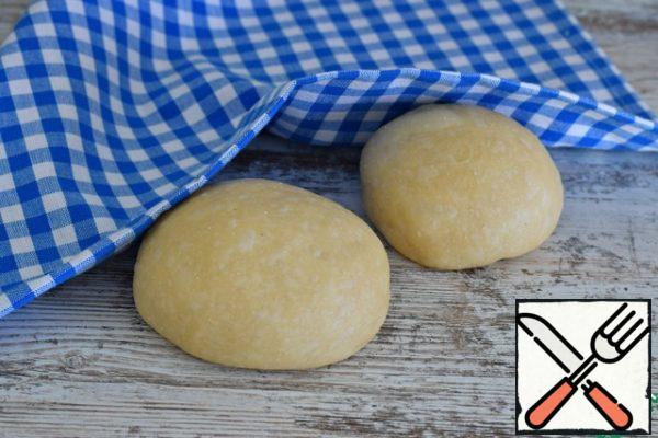 Coming up the dough on the work surface, punch down, divide into two pieces, larger and smaller. (3/5 and 2/5)
A smaller part of the dough to cover with a napkin or a thin towel, so it does not aired. 