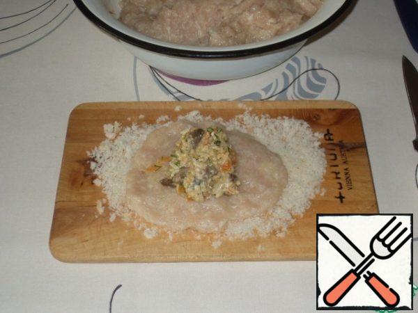 Put a couple of tablespoons of minced meat, arrange it in the form of a flatbread with a wet knife. Put the filling in the middle.
