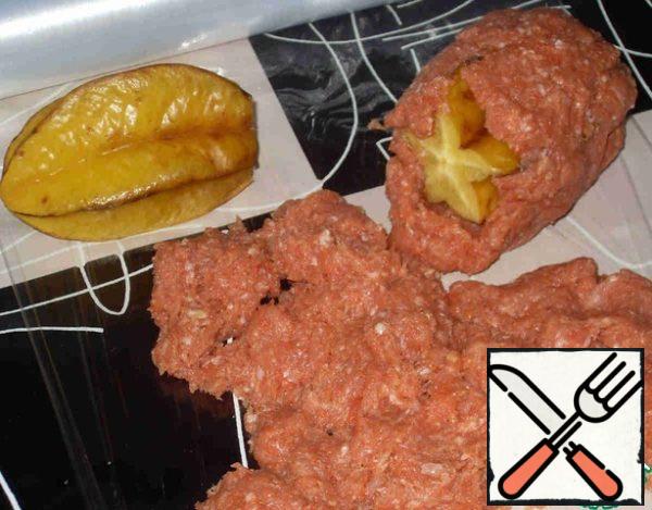 Have cannon cut off a small piece of fruit from the stalk. On the table spread the plastic wrap. Put the minced meat in the cavity of the caroms, connect them with the cut ends and then completely cover with minced meat.