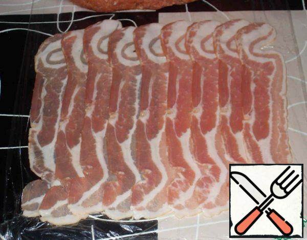 Thin slices of bacon spread on the film a little overlap.