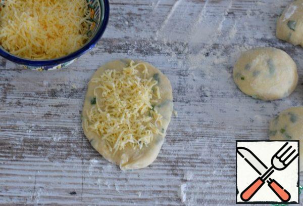 Roll out each part of the dough into an oval cake. The surface of the cake sprinkle with grated cheese. (about 1 tsp)