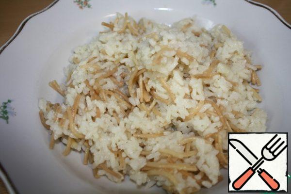 Rinse the rice, drain the water and let it dry.
Pour oil into the pan, you can take part of vegetable and part of butter, or just vegetable. Add a teaspoon of salt or to taste and ground black pepper.
Fry the vermicelli until golden brown, stirring constantly, then add the rice, fry for about 5 minutes and pour in three cups of boiling water. Close the lid, reduce the heat to a minimum and simmer until tender.
