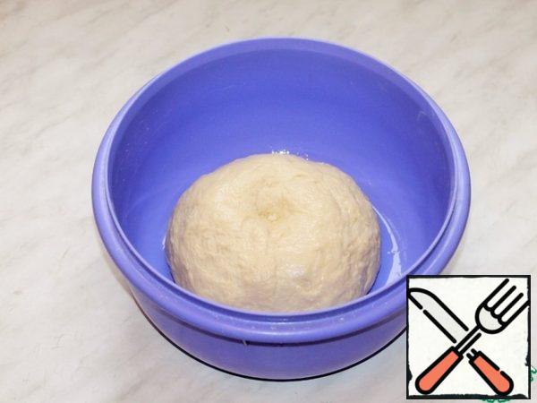 Grease a clean bowl with vegetable oil (0.5 tbsp.), put the dough and scroll. Close the bowl with a film and put in a warm place to increase the dough 2-3 times.