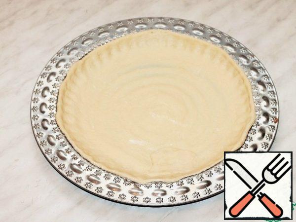 Using a rolling pin, transfer the circle to a greased baking sheet or baking dish (f = 28 cm). Brush the dough with melted butter and sprinkle with starch (1 tsp).
