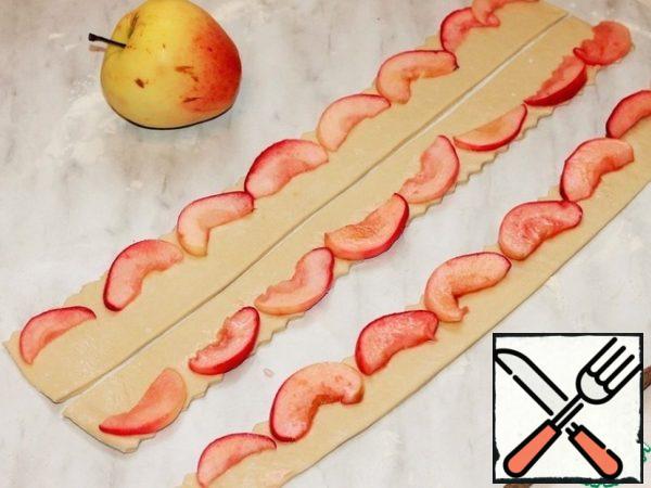 Roll out the third part of the dough into a layer and cut into strips. Cover the top of the cake with curly strips.
And to decorate the cake, prepare the dough and slices of red apple roses.
