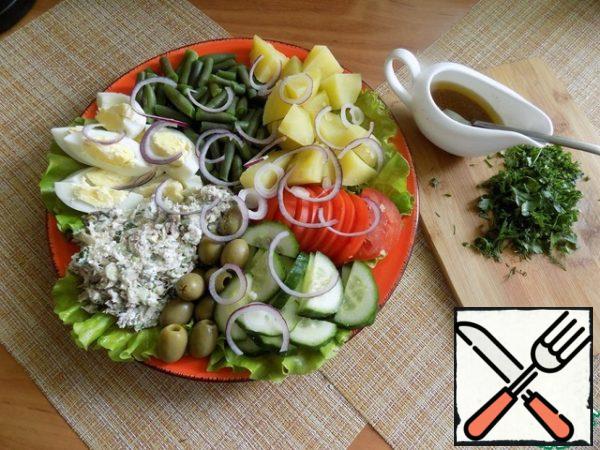 Nice it will be to serve. I picked up a large flat plate. Laid out the bottom of the lettuce leaves. Sectors laid out fish in cheese and vegetables with eggs. Visually divided the plate into sectors by the number of ingredients. See photo. That's the way it is.