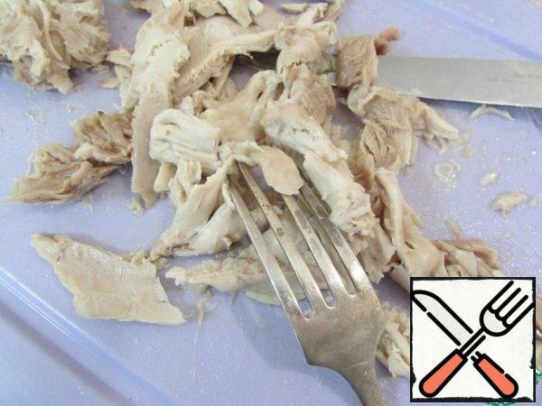The finished chicken is separated from the bone and cut into small pieces.