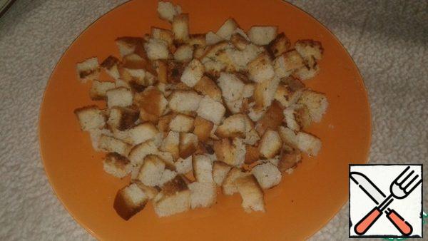 Prepare croutons-croutons. Cut white bread into cubes with a sharp knife and fry in a dry frying pan
