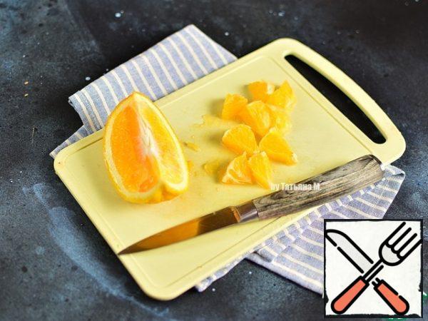 Peel the orange from the peel, seeds and cut into pieces.

