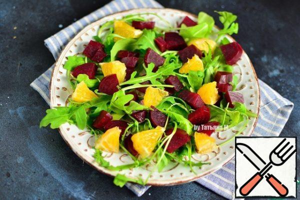 Put the arugula, beetroot and orange on a plate and mix gently.
Break the cheese into a plate in small pieces.