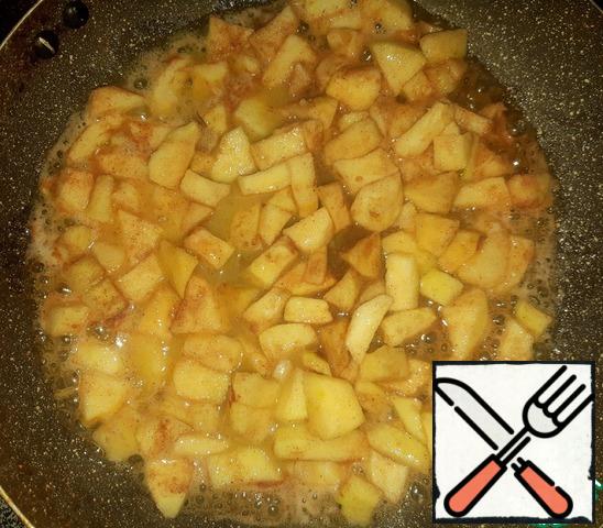In the meantime, let's get on with the apples. They need to be cleaned, cut into small cubes, add sugar, mix well the apples. In a heated pan, add butter and send caramelized apples with sugar, just add cinnamon and ginger to taste. The filling for the buns is ready.