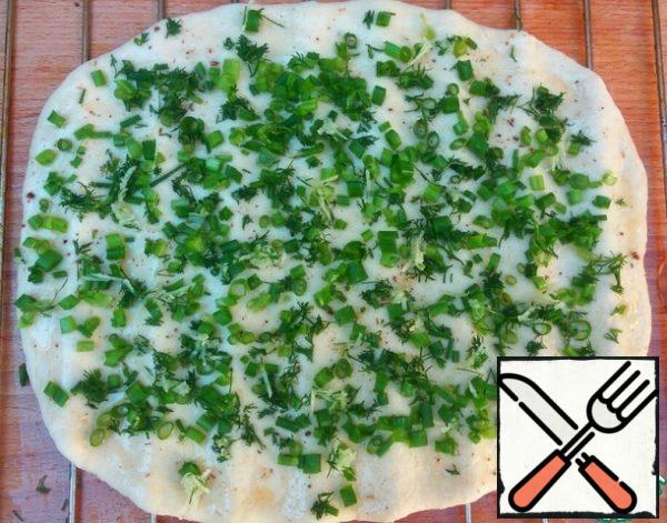 Grill from the oven, too, lubricate oils.
Put the rolled dough oiled side on the grill.
Lubricate also the second side of the dough with oil. Evenly distribute the herbs with the garlic.
