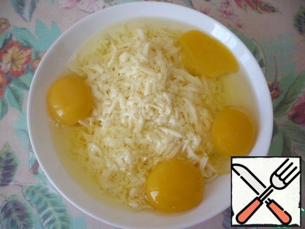 Whisk 4 eggs into the grated cheese.
