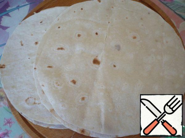 Now take a thin "Armenian pita bread" cut 4 circles the size of the pans.