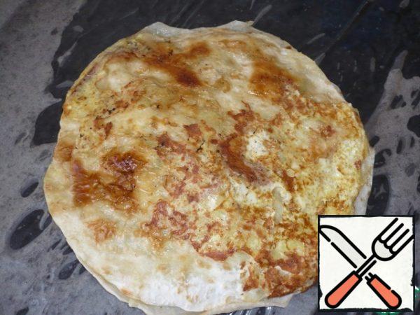 Cover the baking sheet with parchment and brush with sunflower oil. Put one layer of pita bread with filling on parchment.
