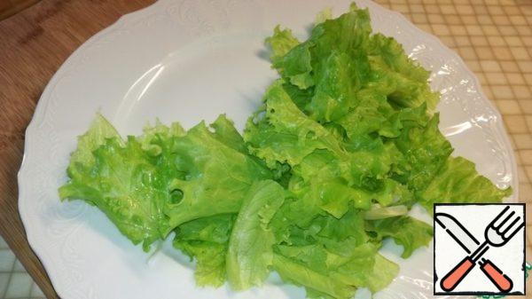 Tear the lettuce leaves arbitrarily with your hands and put on a dish to serve.