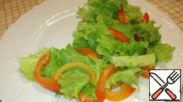 Bulgarian pepper cut into long strips and spread over the lettuce leaves.