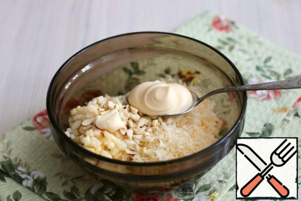 Mix the diced apple, grated cheese, and chopped almonds in a bowl. Season with mayonnaise.
