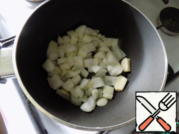 In a saucepan poured olive oil (can be replaced with sunflower), warmed it and put a clove of garlic, cut into 3 parts coarsely. When the garlic gave its flavor to the oil, put the onion finely chopped. Garlic can be removed, I'll do it later.