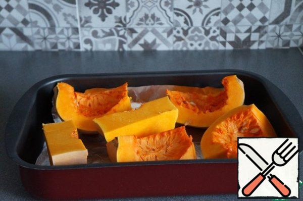 Pumpkin should be cut into pieces, put on a baking sheet.
