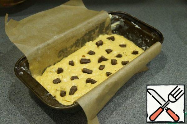 Lay out part of the dough, stick pieces of chocolate into it. In the original there were chocolate drops, they can be immediately kneaded into the dough.

