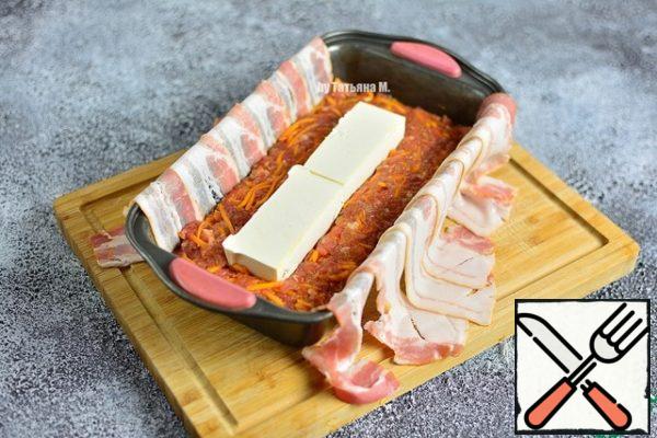 Put half of the filling tightly into the mold.
Cut the cheese into cubes and put it in the middle, slightly pressing into the filling.
