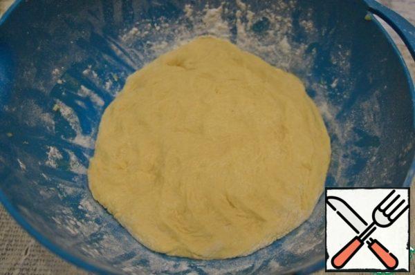 Put the dough in a bowl, powdered with flour. "Smash" on the bottom. Tighten the film or cover with a cloth and put in a warm place for proofing.
