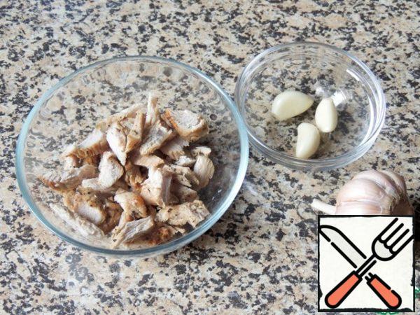 Cut the meat into small pieces. It can be baked or boiled chicken, the remains of barbecue. Crush the garlic.
