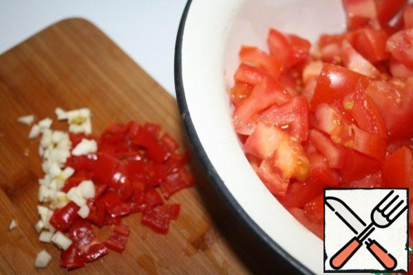 Finely chop the garlic and pepper.
Cut tomatoes into small cubes.
