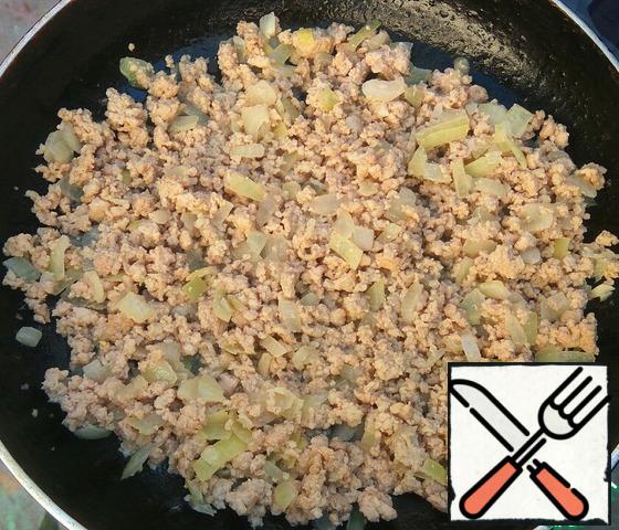 While the dough is suitable, prepare the filling.
Onion cut into small pieces.
Fry in vegetable oil until transparent. To onions add minced meat and crushed garlic. Season with salt and pepper to taste. Fry stirring until the stuffing is ready and the liquid evaporates.