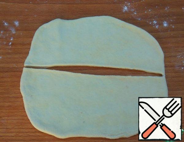 One portion of the dough aside. The remaining 7 parts, roll out into an oval with a thickness of about 2-3 mm.
Cut in half.