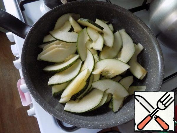 In a frying pan in oil fry a little zucchini. Do not add salt! so the pieces remained intact and he did not give a lot of juice.