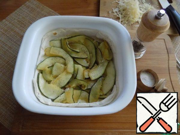 Then-zucchini layer by layer. Top the zucchini with salt, not forgetting the hard cheese and pepper as desired.