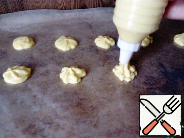 The baking sheet is covered with parchment paper, lubricate with vegetable oil and plant the cookies with a pastry syringe or bag (the diameter of the cookie is about 1.5-2 cm) Put it to bake in a preheated oven to 180 degrees for 5-8 minutes, depending on the oven.