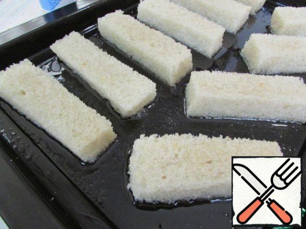 Each bar dipped in vegetable oil to oil completely covered the bread. Put them on a baking sheet. Season with coarse salt. Send in a preheated 180 degree oven.