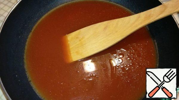 In a heated deep frying pan, add sunflower oil, tomato paste, pour soy sauce and water. Stir well and bring to a boil over medium heat.